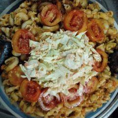 A picture of Macaroni,washed beans with salad, tomatoes and fish.