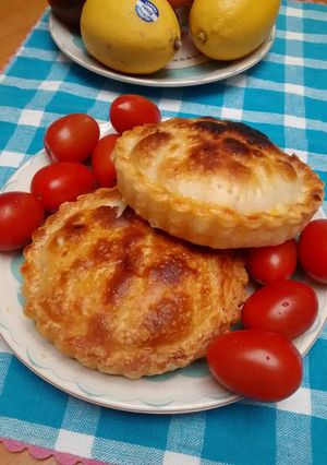 Una foto de Tarteletas de cebolla, pimiento rojo y ajo salteado, con quesos varios