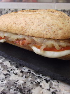 Una foto de Bocadillo de tomate a la plancha, mozzarella y cebolla pochada