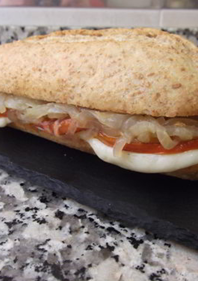 Una foto de Bocadillo de tomate a la plancha, mozzarella y cebolla pochada