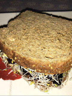 Una foto de Sándwich vegano de aceitunas naturales y brotes de alfalfa