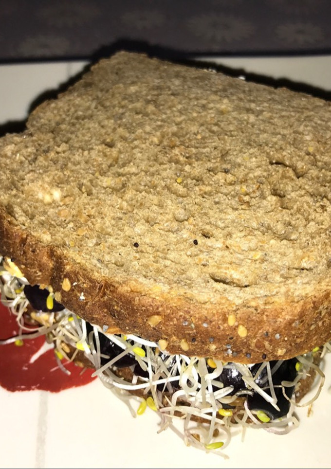 Una foto de Sándwich vegano de aceitunas naturales y brotes de alfalfa