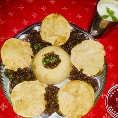 A picture of Navratri special thali (dry kala chana,suji halwa,puri, Charnamrit.