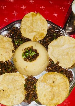 A picture of Navratri special thali (dry kala chana,suji halwa,puri, Charnamrit.