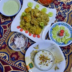 A picture of Yummy chicken pulao with salad, homemade raita,achar, and kheer.