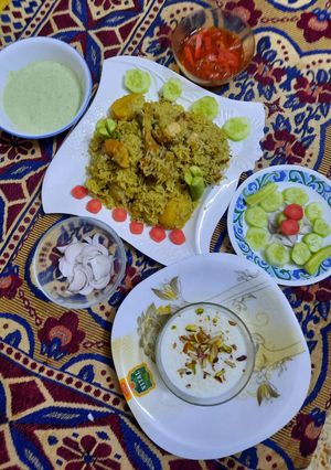 A picture of Yummy chicken pulao with salad, homemade raita,achar, and kheer.