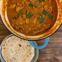 A picture of Butter chicken with instant Roti bread.