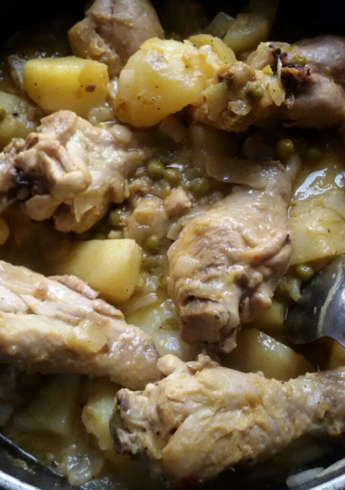 Una foto de Pollos guisados con papas y guisantes