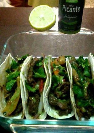 Una foto de Fajitas de carne, vegetales, jalapeño picante, cilantro limón y algunas cositas más 