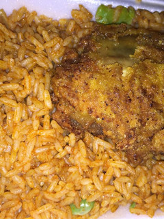 A picture of Jollof rice with chicken breast.