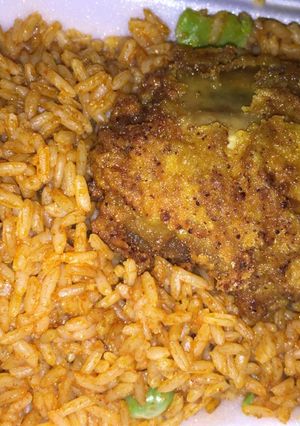 A picture of Jollof rice with chicken breast.