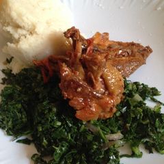 A picture of Deep fried chicken served with kale and ugali.