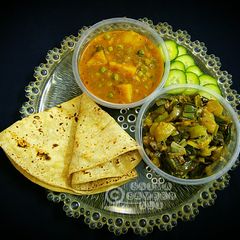 A picture of Aloo matar gravy with Hari pyaz ki bhujiya.
