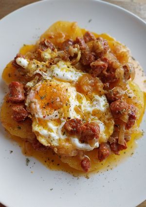 Una foto de Patatas confitadas con chorizo y huevo frito