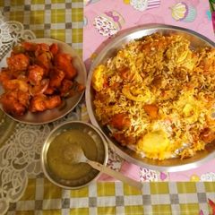 A picture of Chicken biryani With chilli chicken, and coriander chutney.