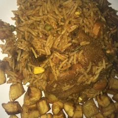 A picture of Smoked goat meat jollof with mixed veggies,plus diced dodo.