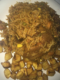 A picture of Smoked goat meat jollof with mixed veggies,plus diced dodo.