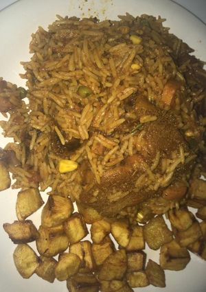A picture of Smoked goat meat jollof with mixed veggies,plus diced dodo.