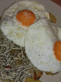 Una foto de Huevos rotos con patatas y gulas del norte