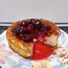 A picture of Tarta de Queso Cremosa con Mermelada de Cereza.