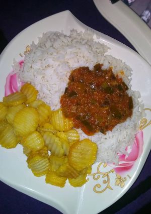 A picture of Rice and stew with chips.