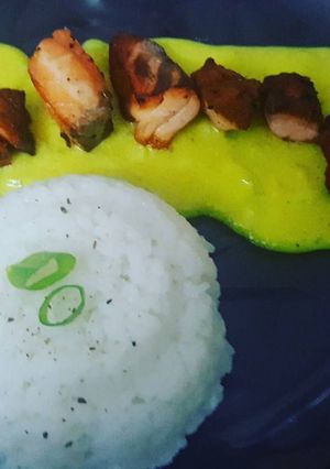 Una foto de Salmón rosado en salsa falsa de azafrán con arroz a la pimienta