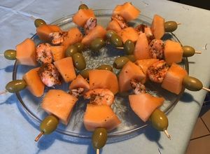 Une photo de Brochettes de melon aux crevettes épicées et olives vertes