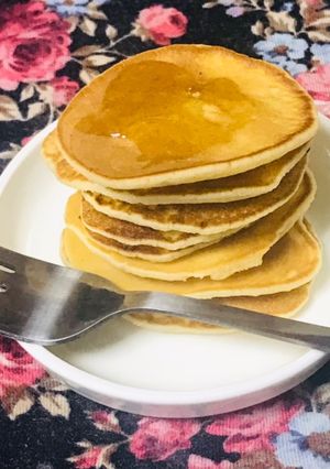 A picture of Dollar pancakes with dash of honey.
