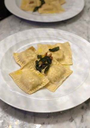 A picture of Homemade crab ravioli with sage lemon butter sauce.