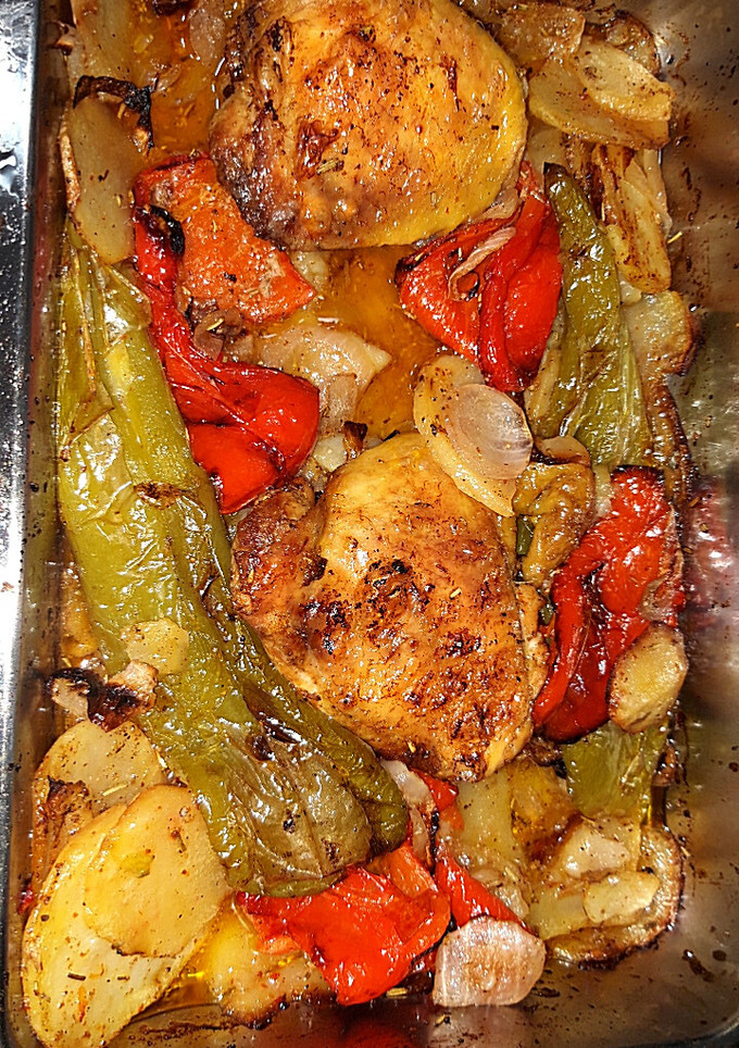Una foto de Pollo al horno con pimientos y cebolla y base de patatas