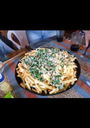 Una foto de Papas con queso cheddar y panceta