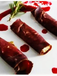 Una foto de Canutillos de cecina con mousse de pato y mermelada de granada