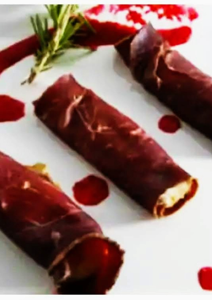Una foto de Canutillos de cecina con mousse de pato y mermelada de granada