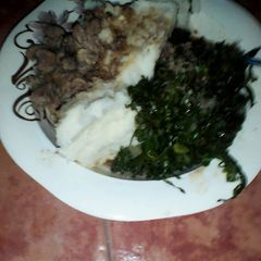 Ugali served with sukuma and beef A picture of Ugali served with sukuma and beef.