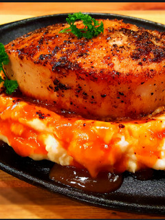 A picture of Mike's Thick Cut Top Loin Pork Chops Over Mashed Potatoes.