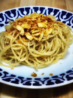 Una foto de Spaghetti con salsa de ajo con anchoas, crujiente tostado casero y parmesano