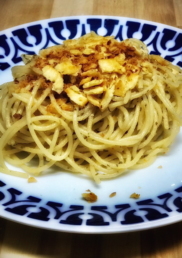 Una foto de Spaghetti con salsa de ajo con anchoas, crujiente tostado casero y parmesano