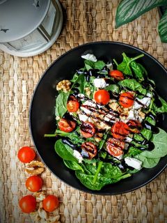 Una foto de Ensalada de espinacas, nueces, queso de cabra y cherrys con vinagre de Módena