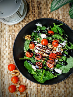 Una foto de Ensalada de espinacas, nueces, queso de cabra y cherrys con vinagre de Módena
