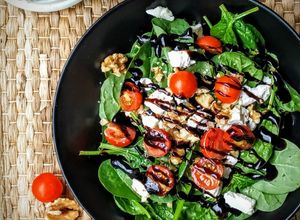 Una foto de Ensalada de espinacas, nueces, queso de cabra y cherrys con vinagre de Módena