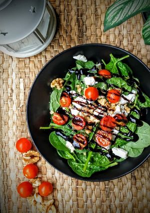 Una foto de Ensalada de espinacas, nueces, queso de cabra y cherrys con vinagre de Módena
