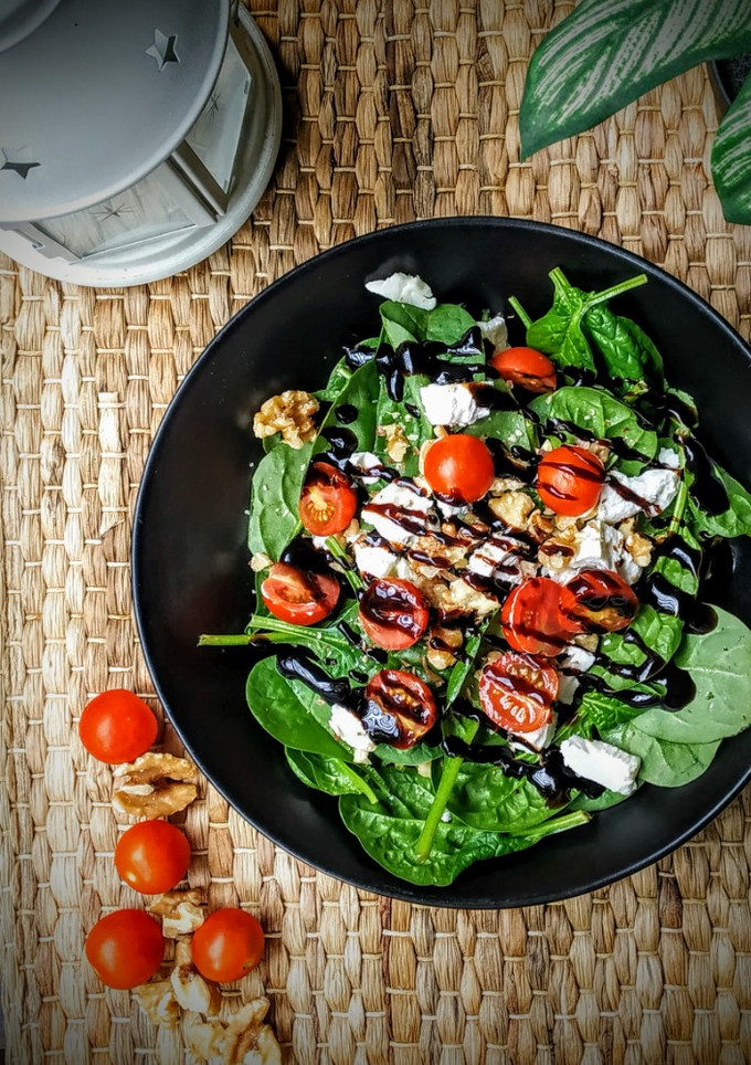 Una foto de Ensalada de espinacas, nueces, queso de cabra y cherrys con vinagre de Módena
