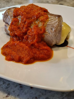 Una foto de Solomillo de cerdo relleno de jamón y queso con salsa de piquillos