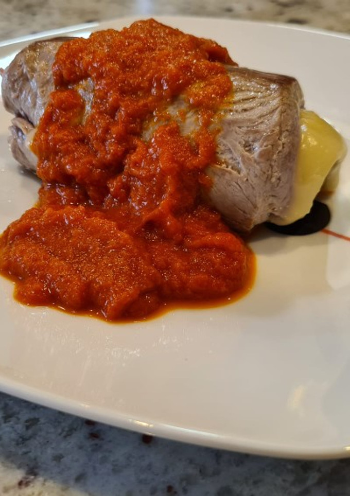Una foto de Solomillo de cerdo relleno de jamón y queso con salsa de piquillos