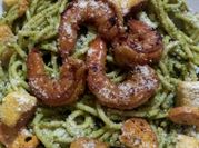 Una foto de pasta con marisco y pesto