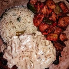 A picture of Chicken steak with mushroom sauce with fried rice and fried vegetables.