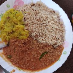 A picture of Minced pilau with peanut flavoured minced meat stew and cabbage.