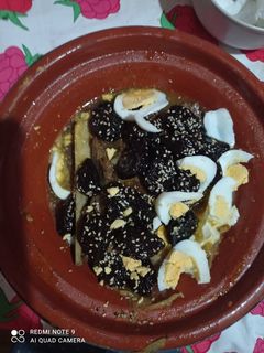 Una foto de Tajín de cordero con ciruelas semillas de sésamo y huevo