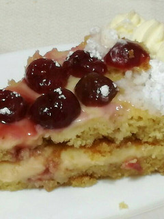Una foto de Tarta de bizcocho de nata con cerezas rellena de crema.🍰