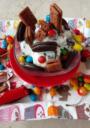 A picture of Vanilla ice cream with oreo and bourbon biscuits.